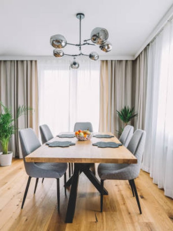 Dining room with wooden table and floor in modern apartment. Interior design